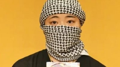 كاتبة يابانية ترتدى الكوفية وعلم فلسطين أثناء تتويجها بجائزة أدبية