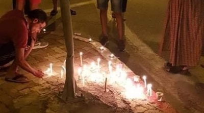 أمنيون ومواطنون يشعلون الشموع مكان العملية الإرهابية (صور)